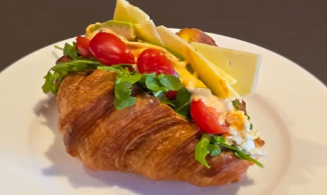 Croissant with Scrambled Eggs Avo Cheese and Tomato